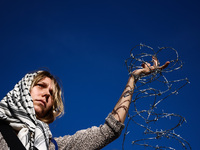 A woman holds barbed wire while attending a demonstration against the Polish government's plans to suspend the right to asylum for refugees...