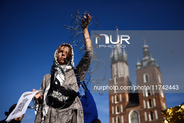 A woman holds barbed wire while attending a demonstration against the Polish government's plans to suspend the right to asylum for refugees...