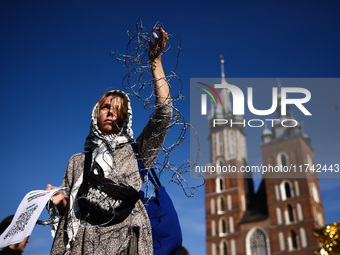 A woman holds barbed wire while attending a demonstration against the Polish government's plans to suspend the right to asylum for refugees...