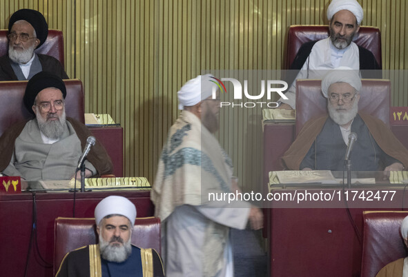 Two Shi'ite Iranian clerics look at a Sunni cleric arriving at the old Iranian Parliament building to take part in Iran's Assembly of Expert...