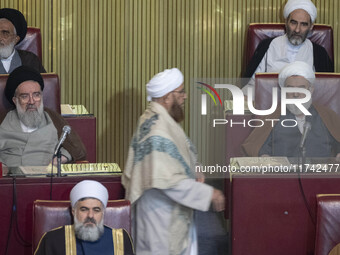 Two Shi'ite Iranian clerics look at a Sunni cleric arriving at the old Iranian Parliament building to take part in Iran's Assembly of Expert...