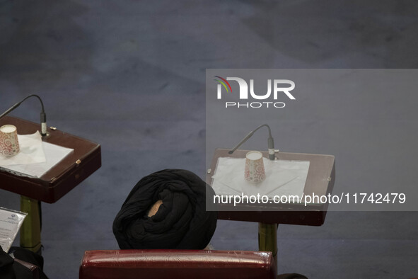 A Shi'ite Iranian cleric sits at the old Iranian Parliament building while taking part in Iran's Assembly of Experts' biannual meeting in Te...