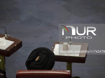 A Shi'ite Iranian cleric sits at the old Iranian Parliament building while taking part in Iran's Assembly of Experts' biannual meeting in Te...