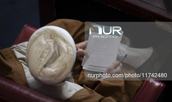 An Iranian cleric holds a note as he sits at the old Iranian Parliament building during Iran's Assembly of Experts' biannual meeting in Tehr...