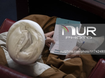 An Iranian cleric holds a note as he sits at the old Iranian Parliament building during Iran's Assembly of Experts' biannual meeting in Tehr...