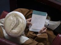 An Iranian cleric holds a note as he sits at the old Iranian Parliament building during Iran's Assembly of Experts' biannual meeting in Tehr...