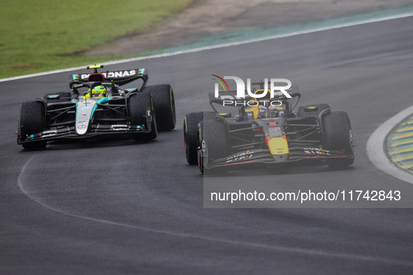 Max Verstappen of Red Bull Racing RB20 and Lewis Hamilton of Mercedes AMG F1 Team W15 compete during the Formula 1 Grand Prix of Brazil at A...