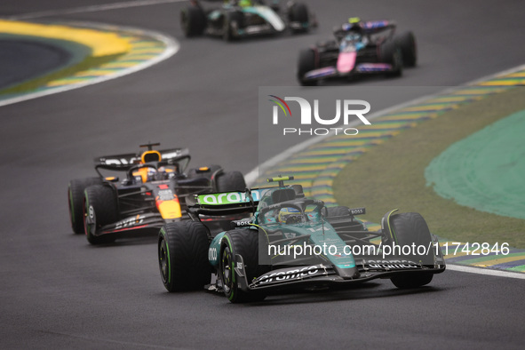 Fernando Alonso of Aston Martin F1 Team AMR24 and Max Verstappen of Red Bull Racing RB20 compete during the Formula 1 Grand Prix of Brazil a...