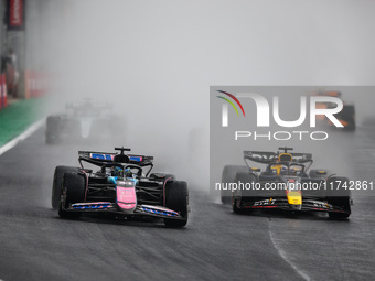 Esteban Ocon of the Alpine F1 Team A524 and Max Verstappen of Red Bull Racing RB20 participate in the Formula 1 Grand Prix of Brazil at Auto...