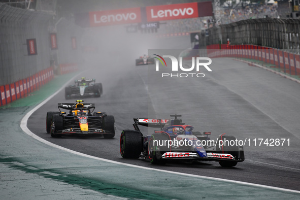 Liam Lawson of Visa Cash App RB F1 Team VCARB 01 and Sergio Perez of Red Bull Racing RB20 participate in the Formula 1 Grand Prix of Brazil...