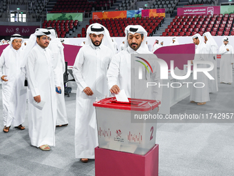 Qatari men cast their votes in ballot boxes at a polling station in a general referendum on constitutional amendments, including scrapping a...