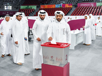 Qatari men cast their votes in ballot boxes at a polling station in a general referendum on constitutional amendments, including scrapping a...