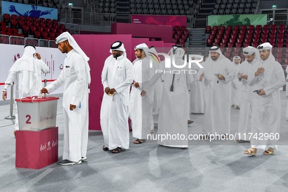 Qatari men cast their votes in ballot boxes at a polling station in a general referendum on constitutional amendments, including scrapping a...