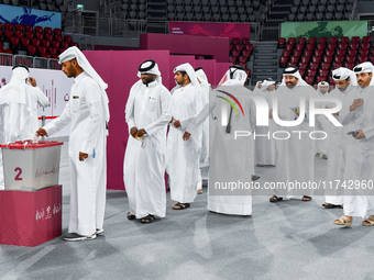 Qatari men cast their votes in ballot boxes at a polling station in a general referendum on constitutional amendments, including scrapping a...