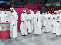 Qatari men cast their votes in ballot boxes at a polling station in a general referendum on constitutional amendments, including scrapping a...