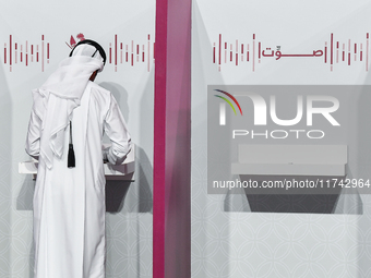 A Qatari man casts his ballot at a polling station in a general referendum on constitutional amendments, including scrapping advisory counci...