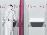 A Qatari man casts his ballot at a polling station in a general referendum on constitutional amendments, including scrapping advisory counci...