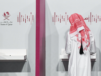 A Qatari man casts his ballot at a polling station in a general referendum on constitutional amendments, including scrapping advisory counci...