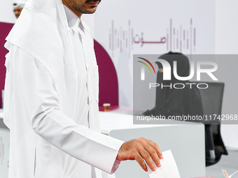 A Qatari man casts his ballot at a polling station in a general referendum on constitutional amendments, including scrapping advisory counci...