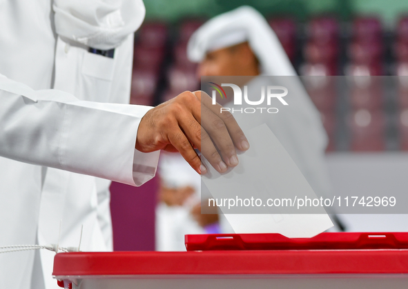 A Qatari man casts his ballot at a polling station in a general referendum on constitutional amendments, including scrapping advisory counci...