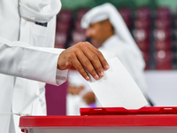 A Qatari man casts his ballot at a polling station in a general referendum on constitutional amendments, including scrapping advisory counci...