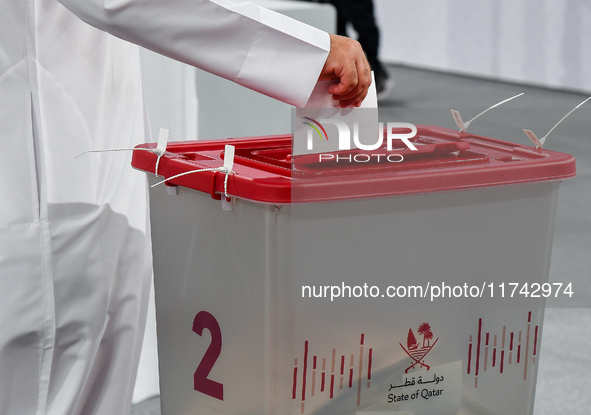 A Qatari man casts his ballot at a polling station in a general referendum on constitutional amendments, including scrapping advisory counci...