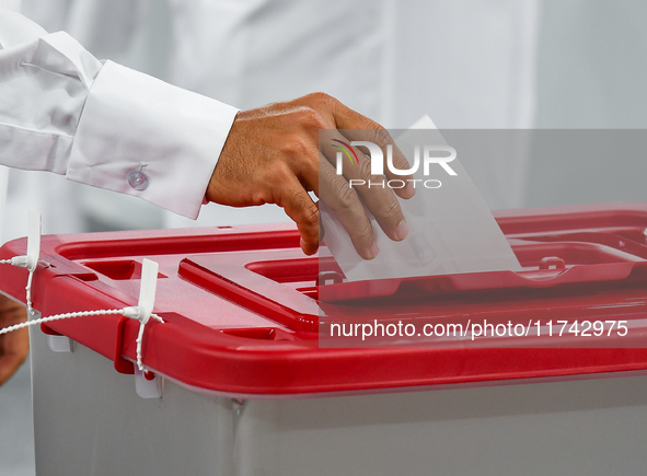 A Qatari man casts his ballot at a polling station in a general referendum on constitutional amendments, including scrapping advisory counci...