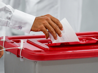 A Qatari man casts his ballot at a polling station in a general referendum on constitutional amendments, including scrapping advisory counci...