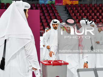 Qatari men cast their votes in ballot boxes at a polling station in a general referendum on constitutional amendments, including scrapping a...