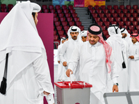 Qatari men cast their votes in ballot boxes at a polling station in a general referendum on constitutional amendments, including scrapping a...