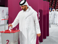 Qatari men cast their votes in ballot boxes at a polling station in a general referendum on constitutional amendments, including scrapping a...