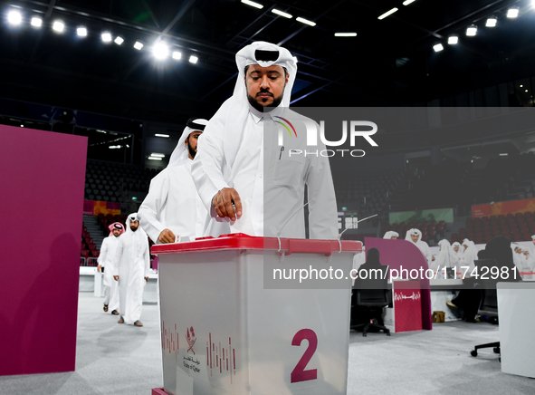 Qatari men cast their votes in ballot boxes at a polling station in a general referendum on constitutional amendments, including scrapping a...