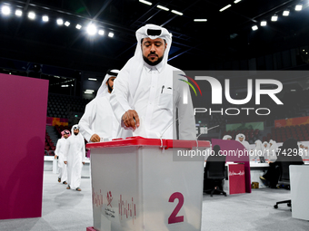 Qatari men cast their votes in ballot boxes at a polling station in a general referendum on constitutional amendments, including scrapping a...