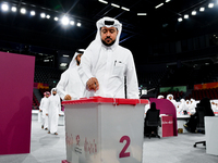 Qatari men cast their votes in ballot boxes at a polling station in a general referendum on constitutional amendments, including scrapping a...