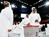 Qatari men cast their votes in ballot boxes at a polling station in a general referendum on constitutional amendments, including scrapping a...