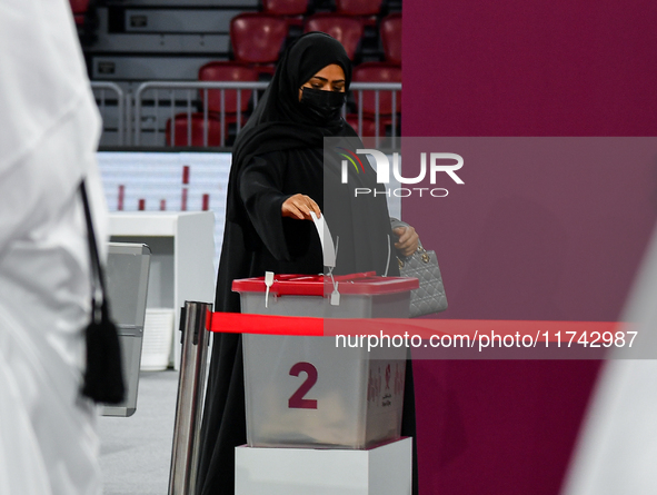 A Qatari woman casts her vote at a polling station in a general referendum on constitutional amendments, including scrapping advisory counci...