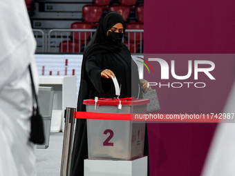 A Qatari woman casts her vote at a polling station in a general referendum on constitutional amendments, including scrapping advisory counci...