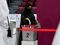 A Qatari woman casts her vote at a polling station in a general referendum on constitutional amendments, including scrapping advisory counci...