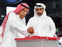 Qatari men cast their votes in ballot boxes at a polling station in a general referendum on constitutional amendments, including scrapping a...