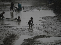 Boys catch fish in the polluted water on the banks of the river Ganges in Prayagraj, India, on November 5, 2024. (