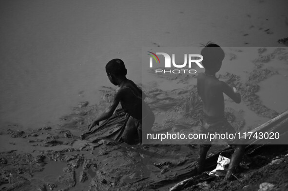 Boys catch fish in the polluted water on the banks of the river Ganges in Prayagraj, India, on November 5, 2024. 