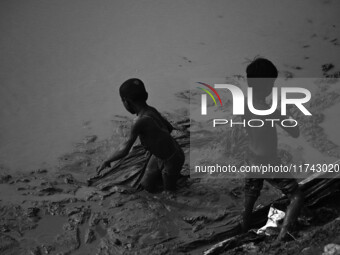 Boys catch fish in the polluted water on the banks of the river Ganges in Prayagraj, India, on November 5, 2024. (