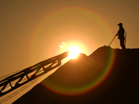 A worker levels sea salt on a salt mountain at the Dongfeng Salt Factory in Hetao Street, Chengyang district, in Qingdao, China, on November...