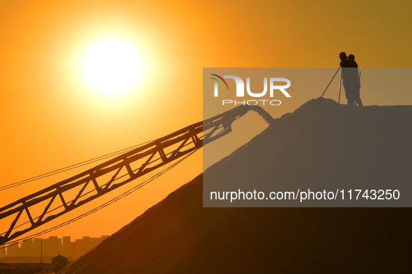 Sea salt from the autumn harvest is stacked on a conveyor belt at the Dongfeng Salt Farm in Hetao Street, Chengyang district, in Qingdao, Ch...