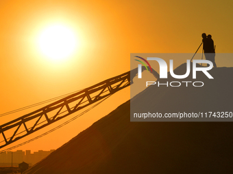 Sea salt from the autumn harvest is stacked on a conveyor belt at the Dongfeng Salt Farm in Hetao Street, Chengyang district, in Qingdao, Ch...