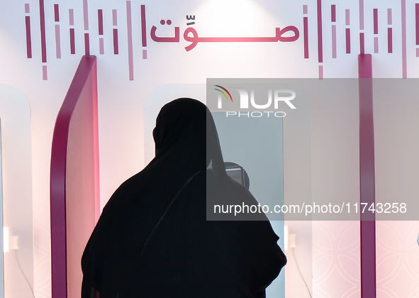 A Qatari woman casts her electronic vote at a polling station in Doha, Qatar, on November 5, 2024, in a general referendum on constitutional...