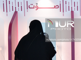 A Qatari woman casts her electronic vote at a polling station in Doha, Qatar, on November 5, 2024, in a general referendum on constitutional...