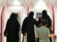 Qatari voters cast their electronic votes at a polling station in a general referendum on constitutional amendments, including scrapping adv...