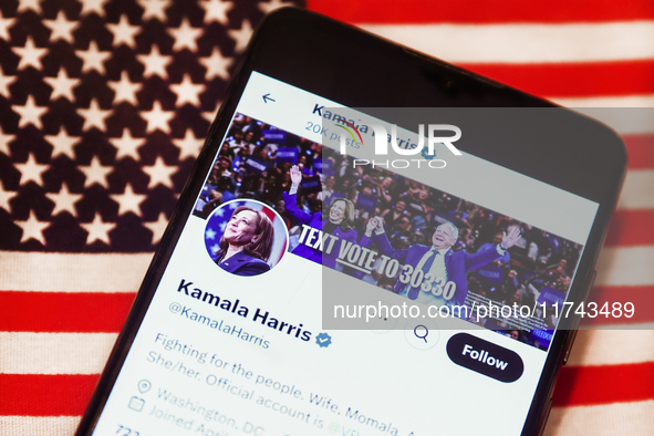 Kamala Harris social media site on X, formerly known as Twitter, is displayed on a mobile phone screen with US flag in the background for il...