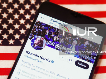 Kamala Harris social media site on X, formerly known as Twitter, is displayed on a mobile phone screen with US flag in the background for il...